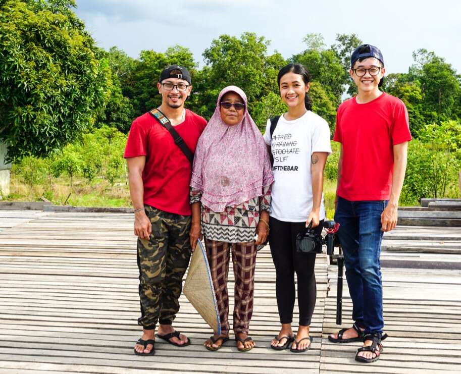The daun Harapan team with a local kratom farmer with kratom trees in the background